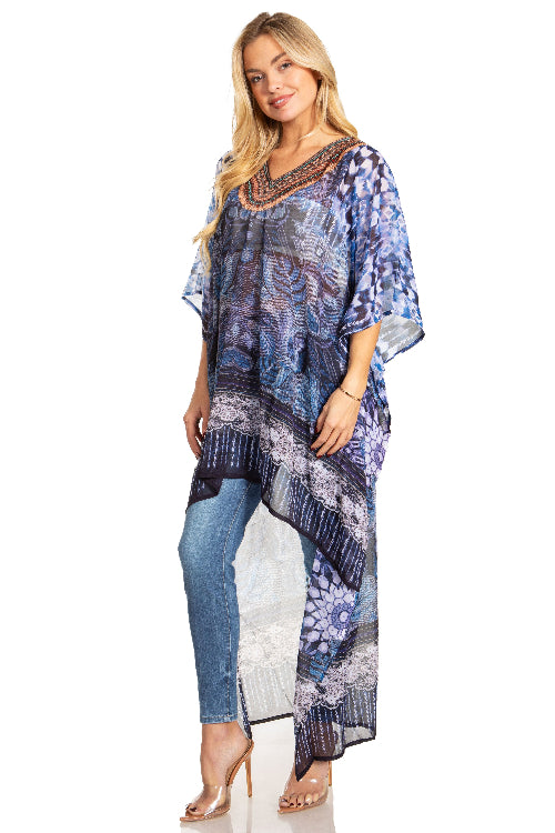 Woman wearing a blue patterned kaftan over jeans on a white background