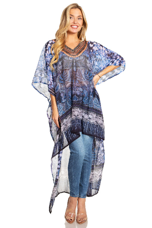 Woman wearing a blue patterned poncho over jeans on a white background