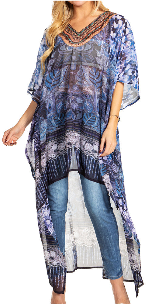 Woman wearing a long, patterned blue dress over jeans on a white background