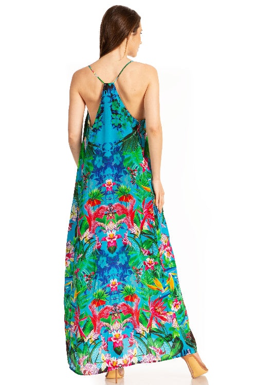 Woman wearing a colorful floral and flamingo patterned dress on a white background
