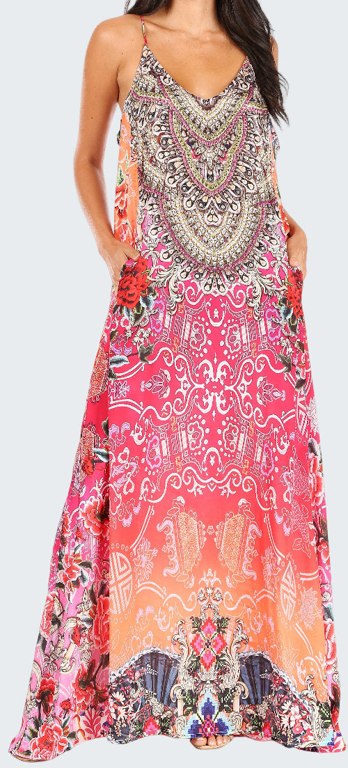 Woman wearing a colorful patterned maxi dress on a white background