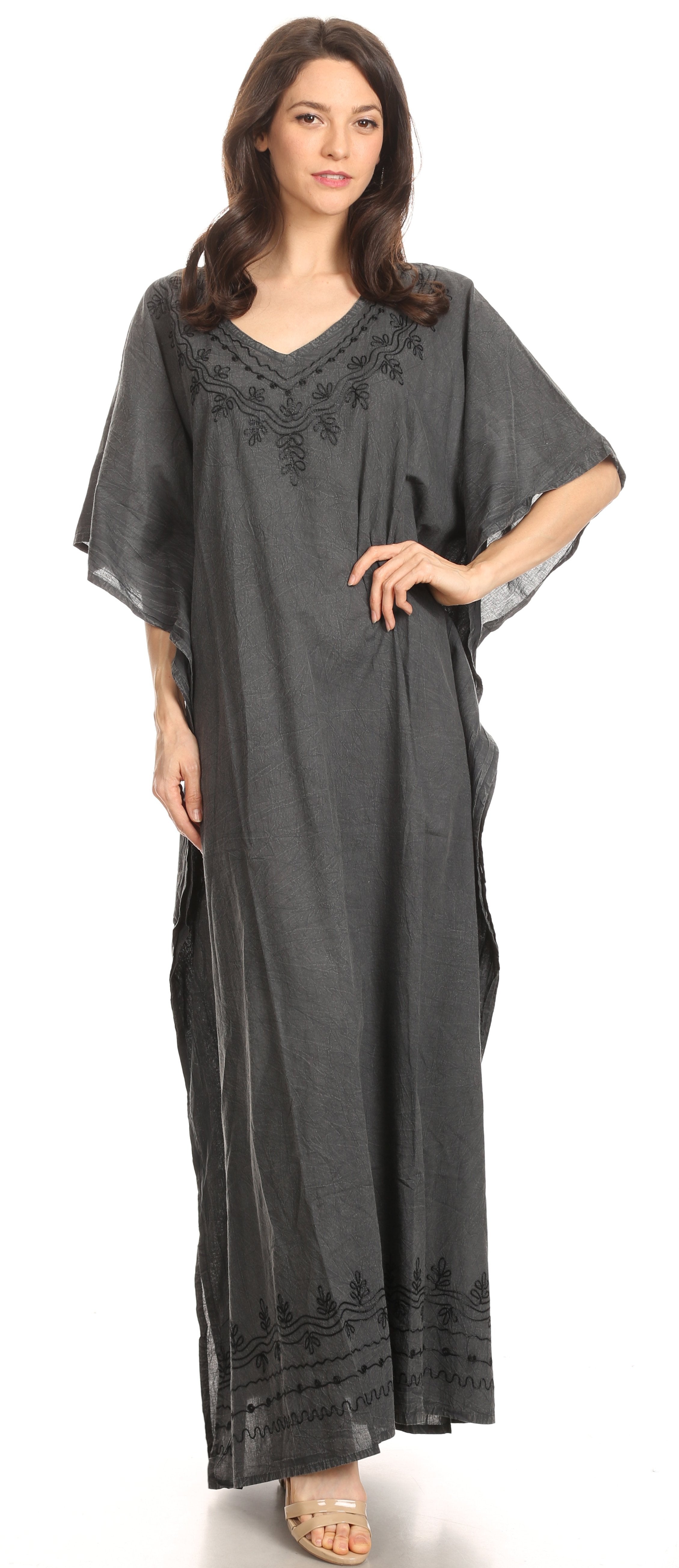 Woman wearing a dark gray caftan with embroidery on a white background