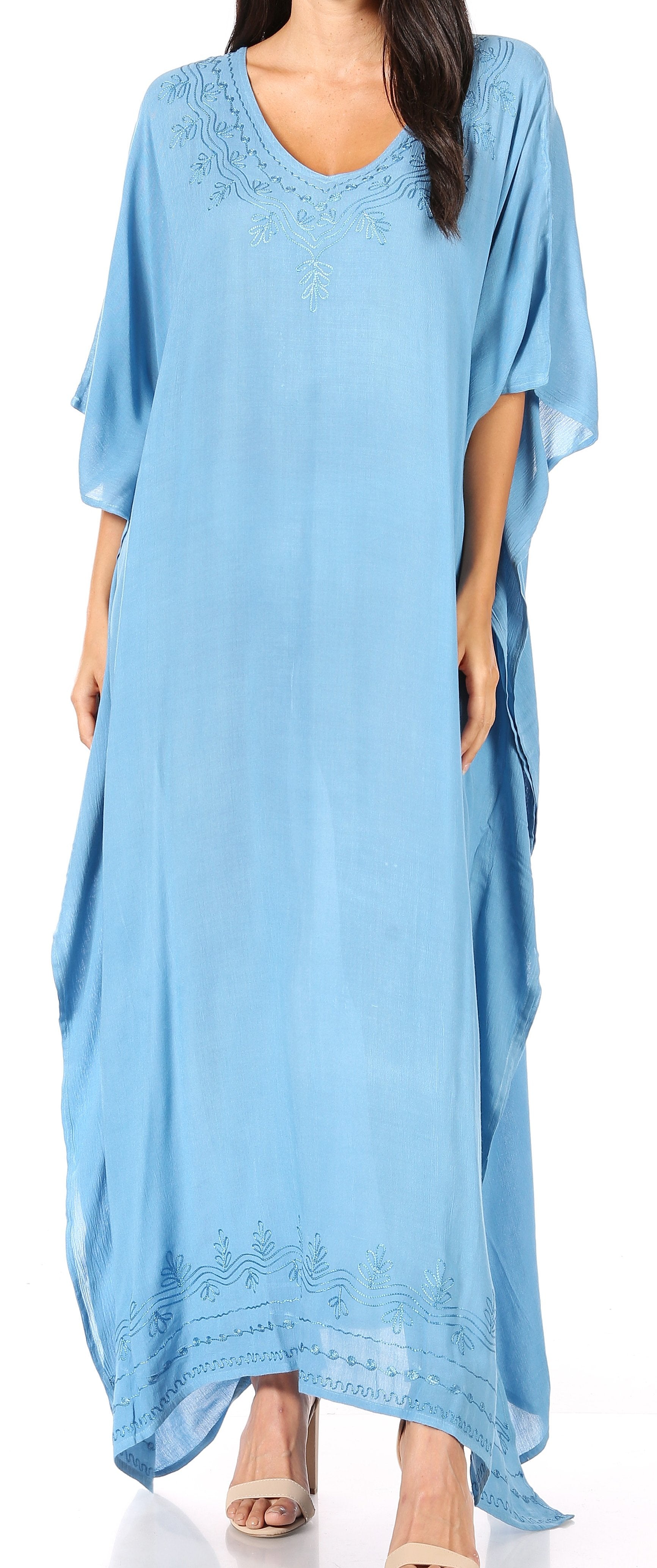 Woman wearing a light blue dress with lace details on a plain background