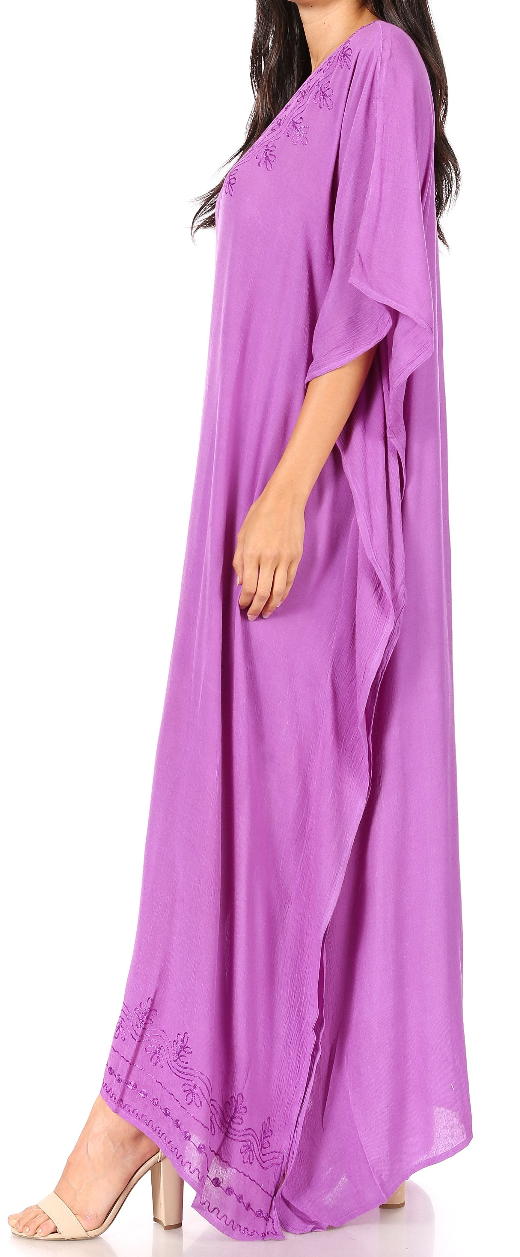 Woman wearing a long purple dress with a plain background