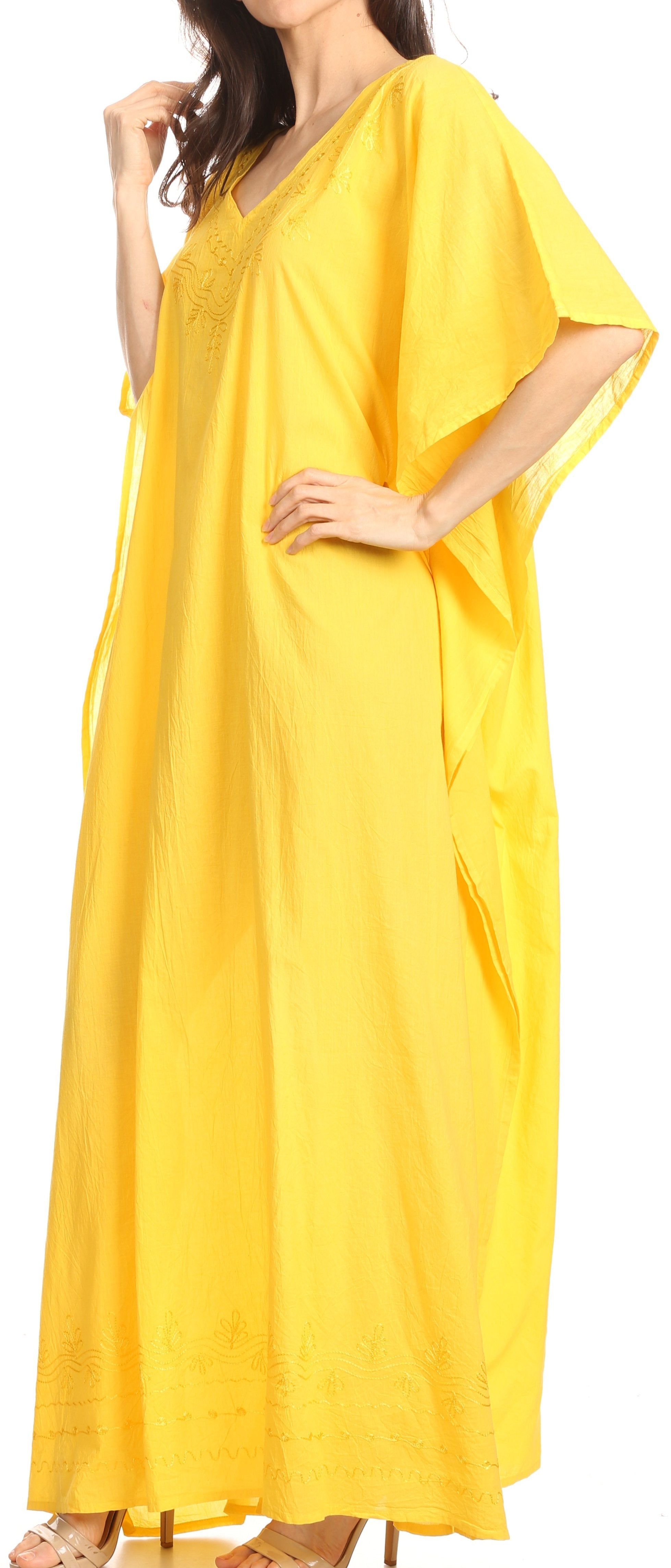 Woman wearing a yellow caftan dress against a neutral background