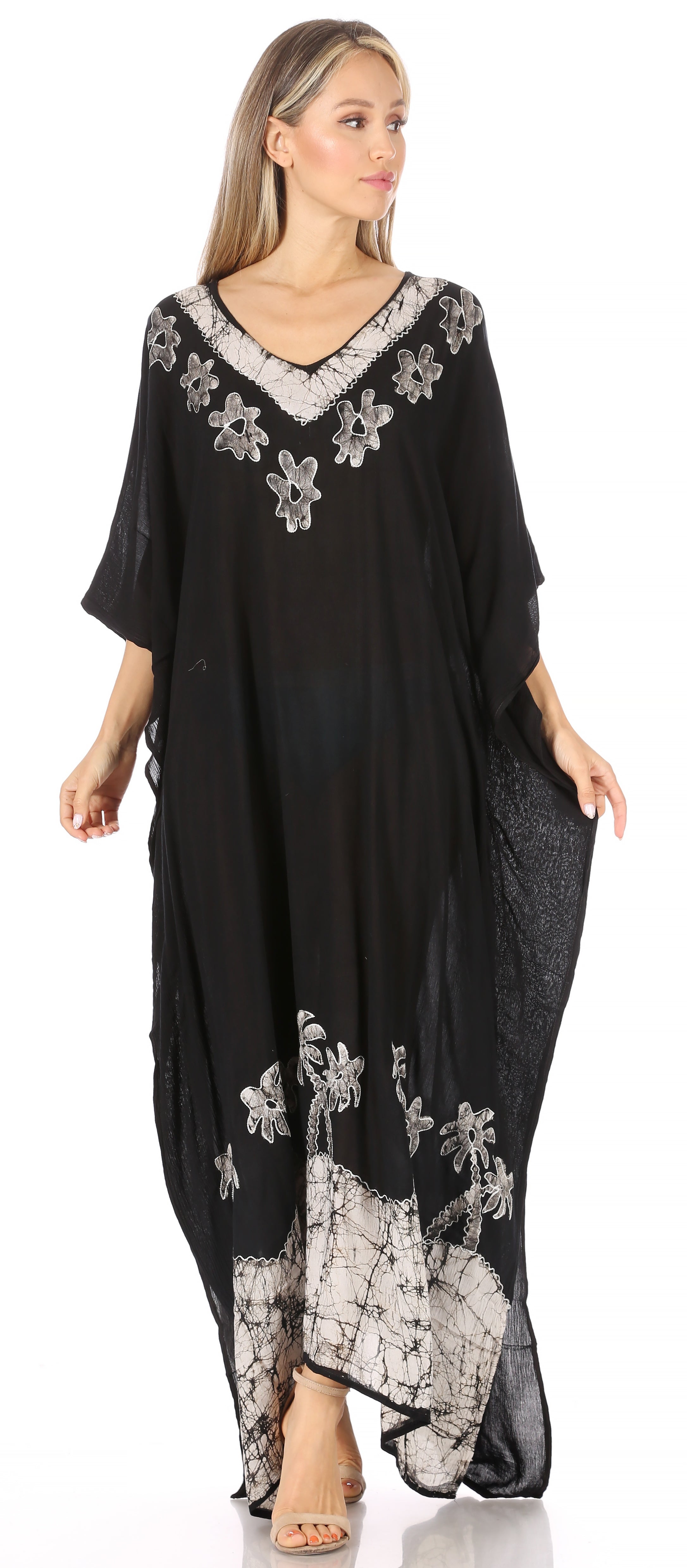 Woman wearing a black dress with floral embroidery on a white background
