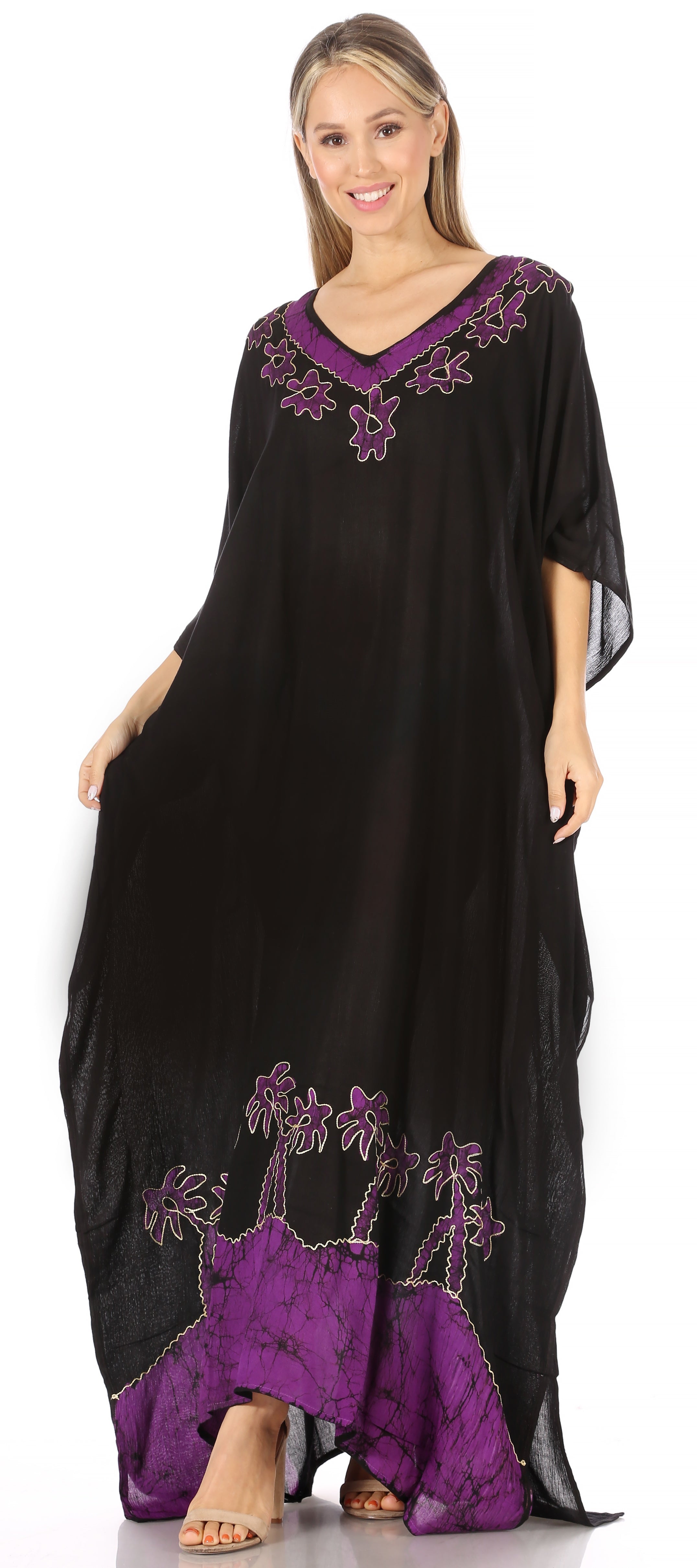 Woman wearing a black and purple dress with palm tree designs on a white background