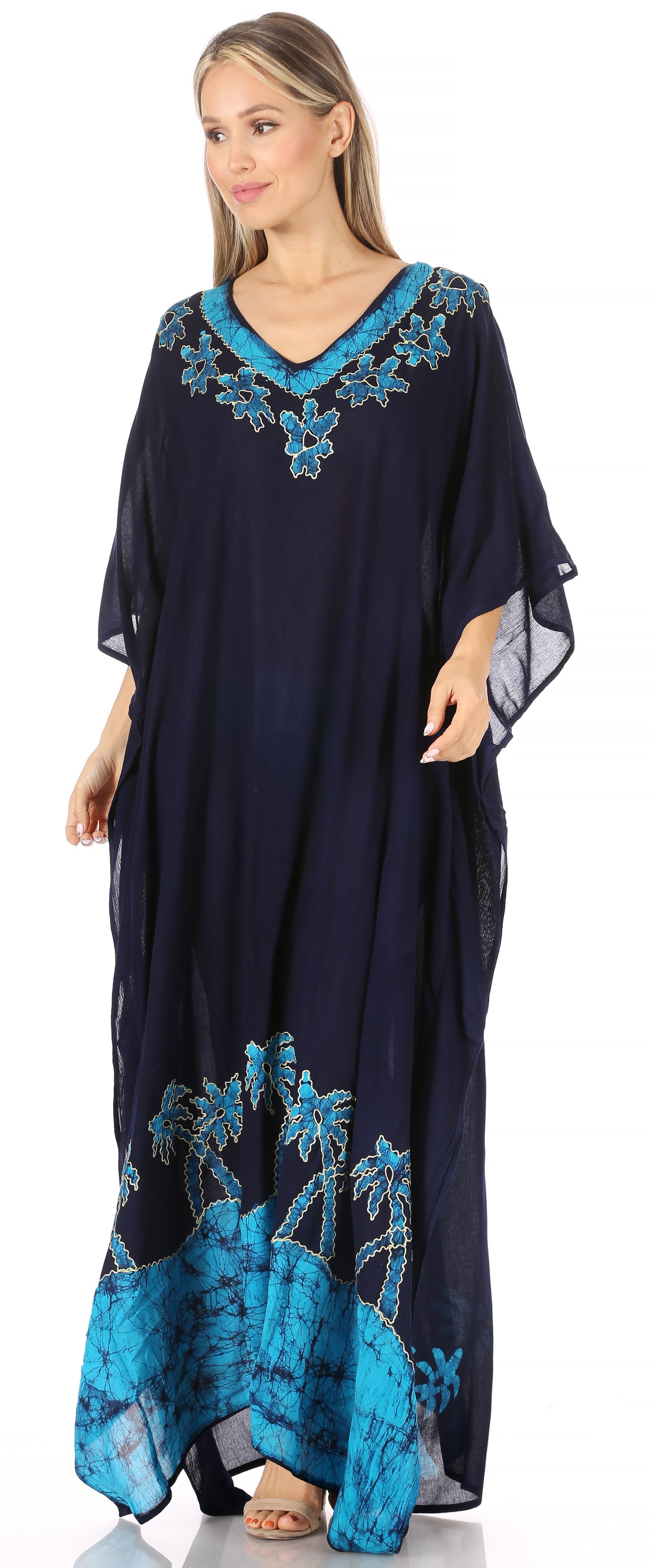 Woman wearing a navy blue dress with turquoise embroidery on a white background
