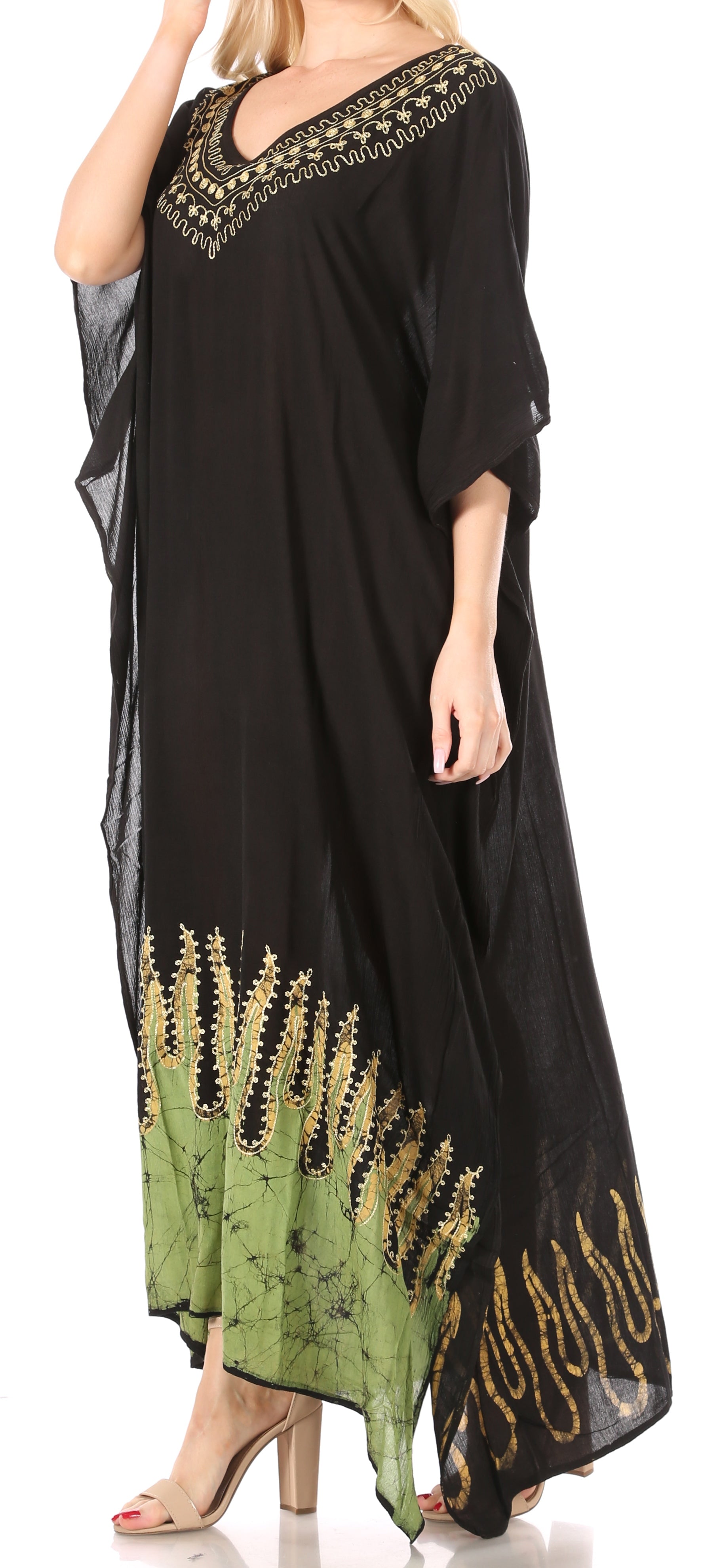 Black dress with green floral patterns and embellishments on a white background
