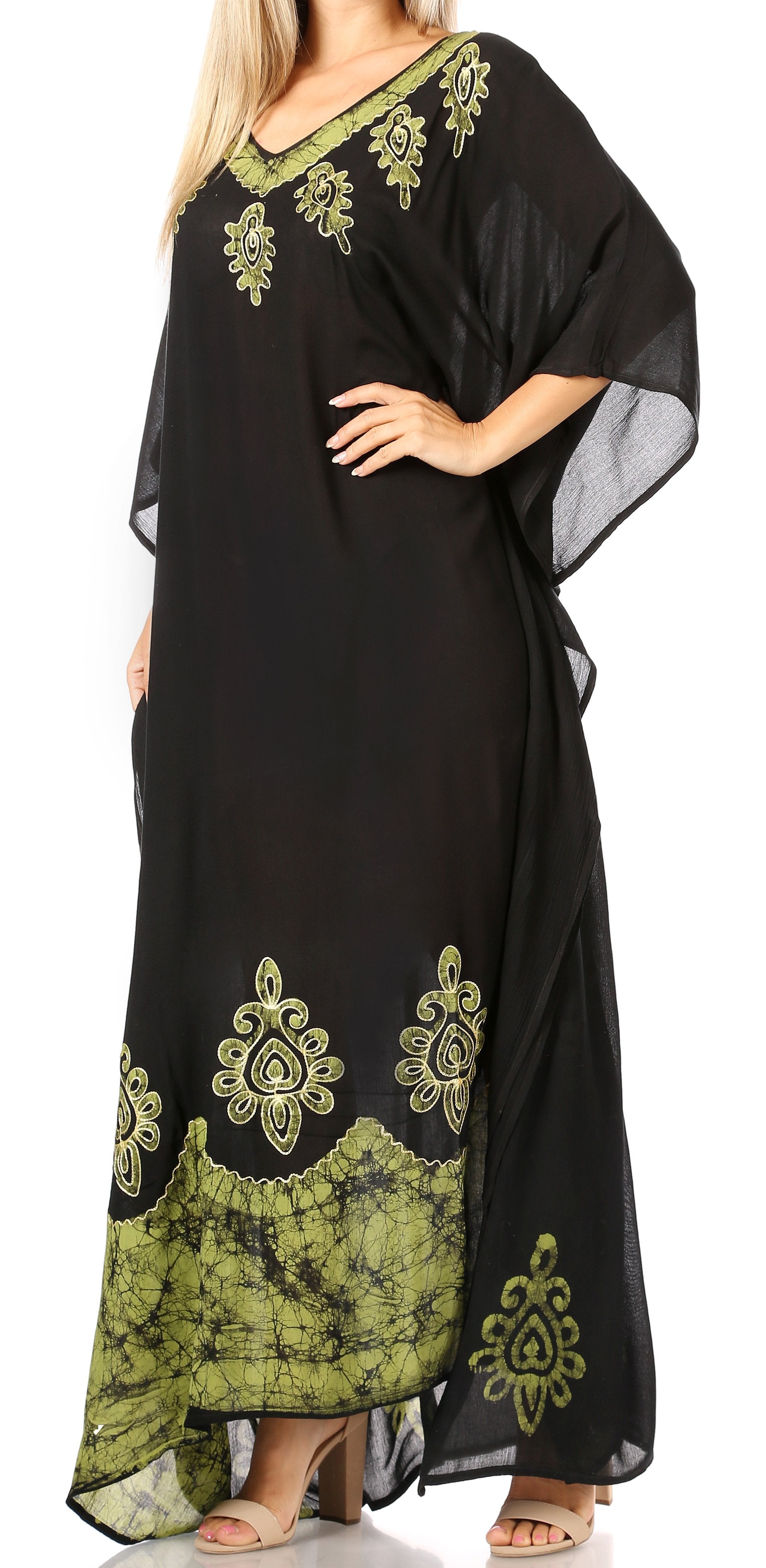 Black and green embroidered dress worn by a model on a white background