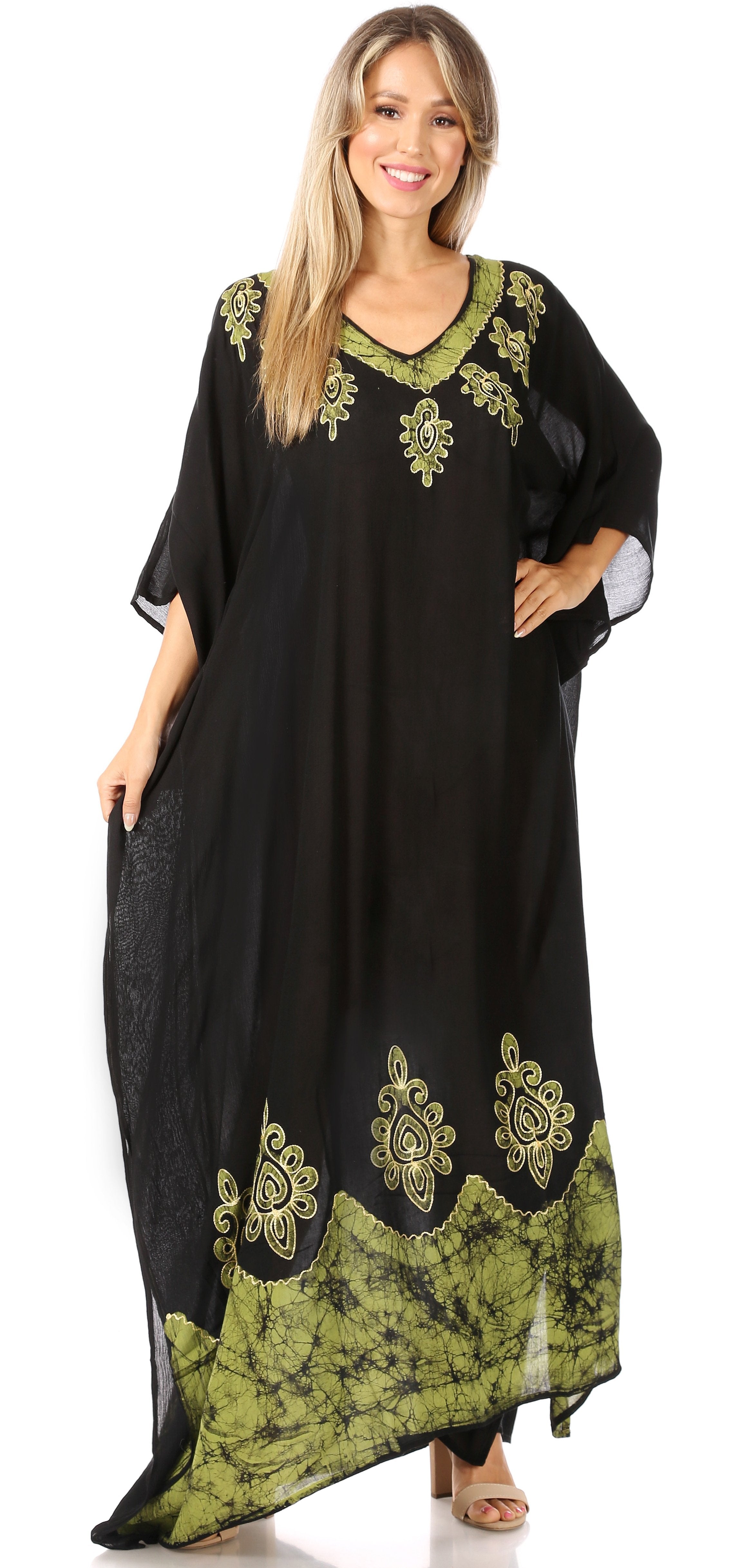 Woman wearing a black and green embroidered dress on a white background