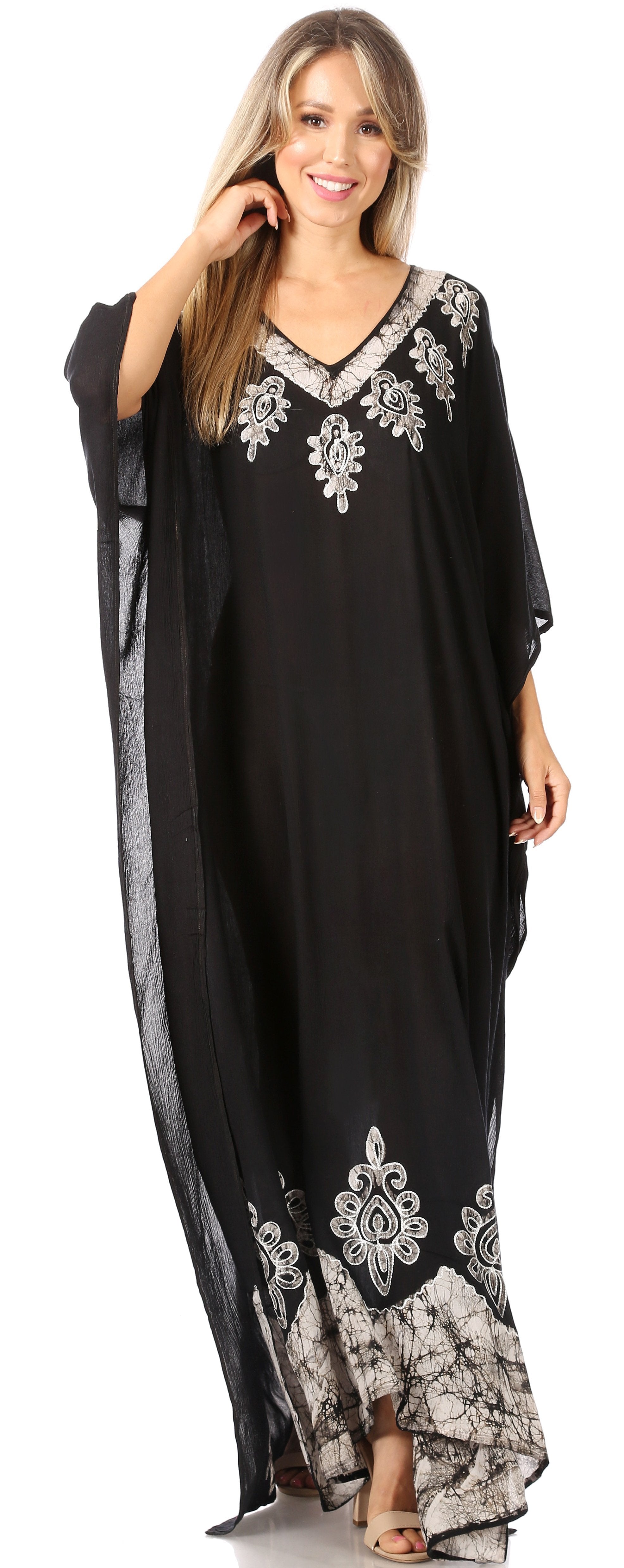 Woman wearing a black dress with silver embroidery on a white background