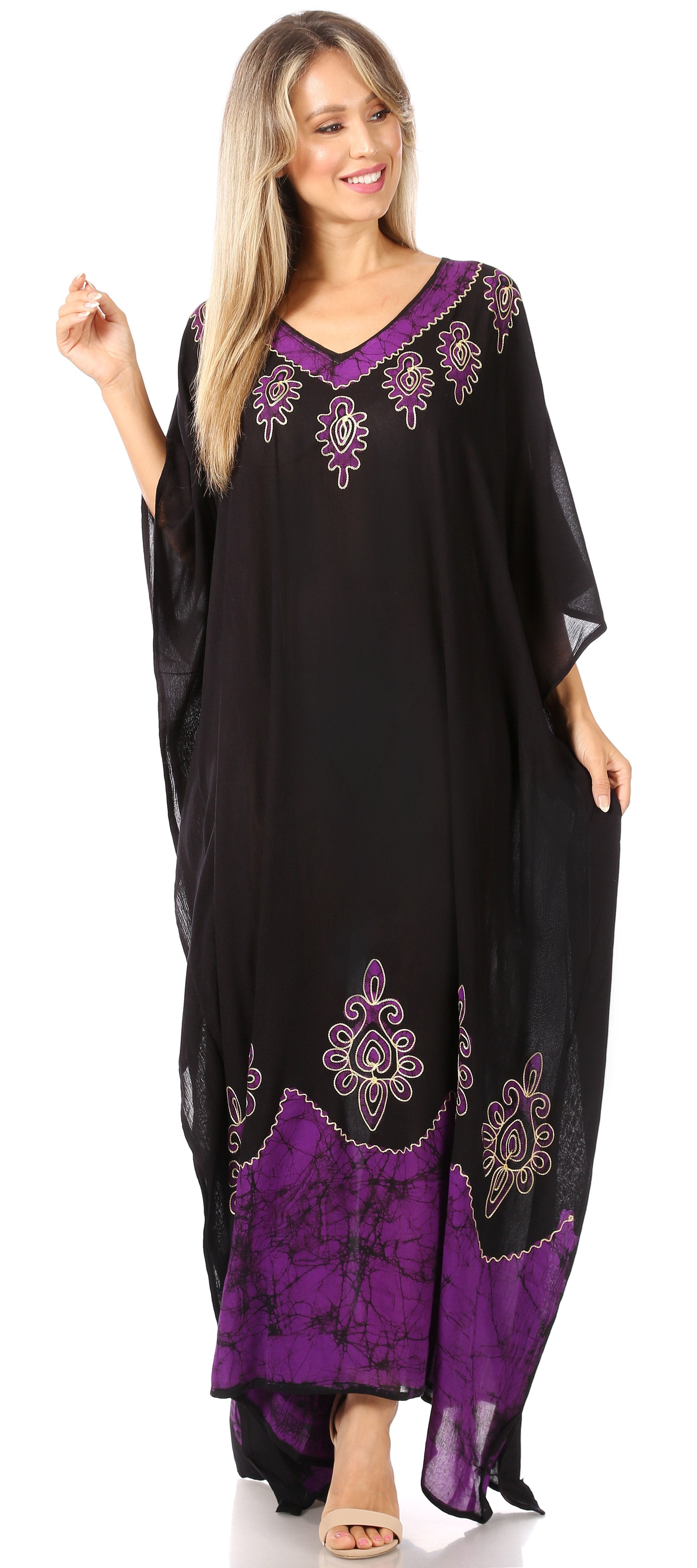 Woman wearing a black and purple caftan with floral embroidery on a white background