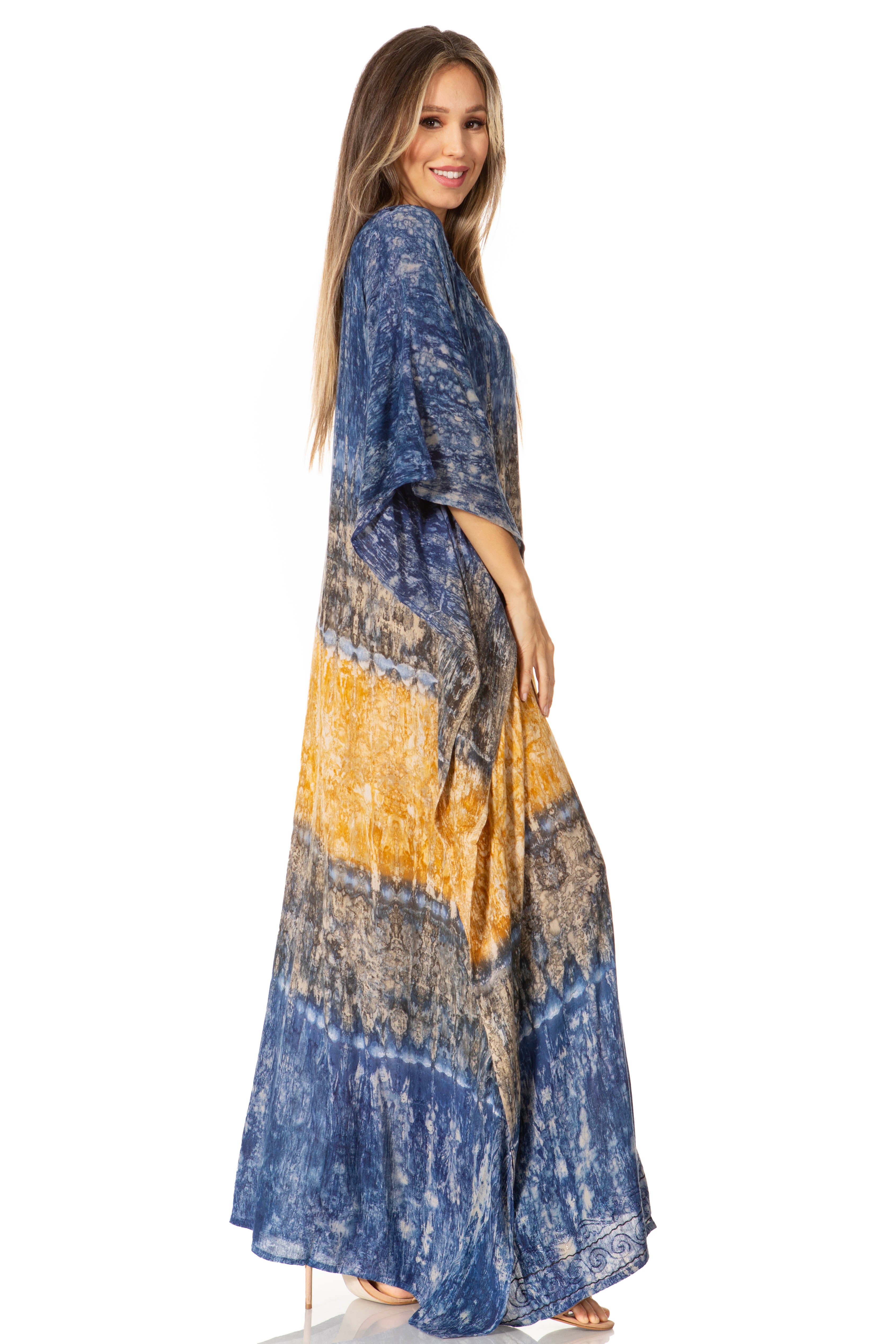 Woman wearing a long, patterned dress with blue, yellow, and brown colors on a white background.