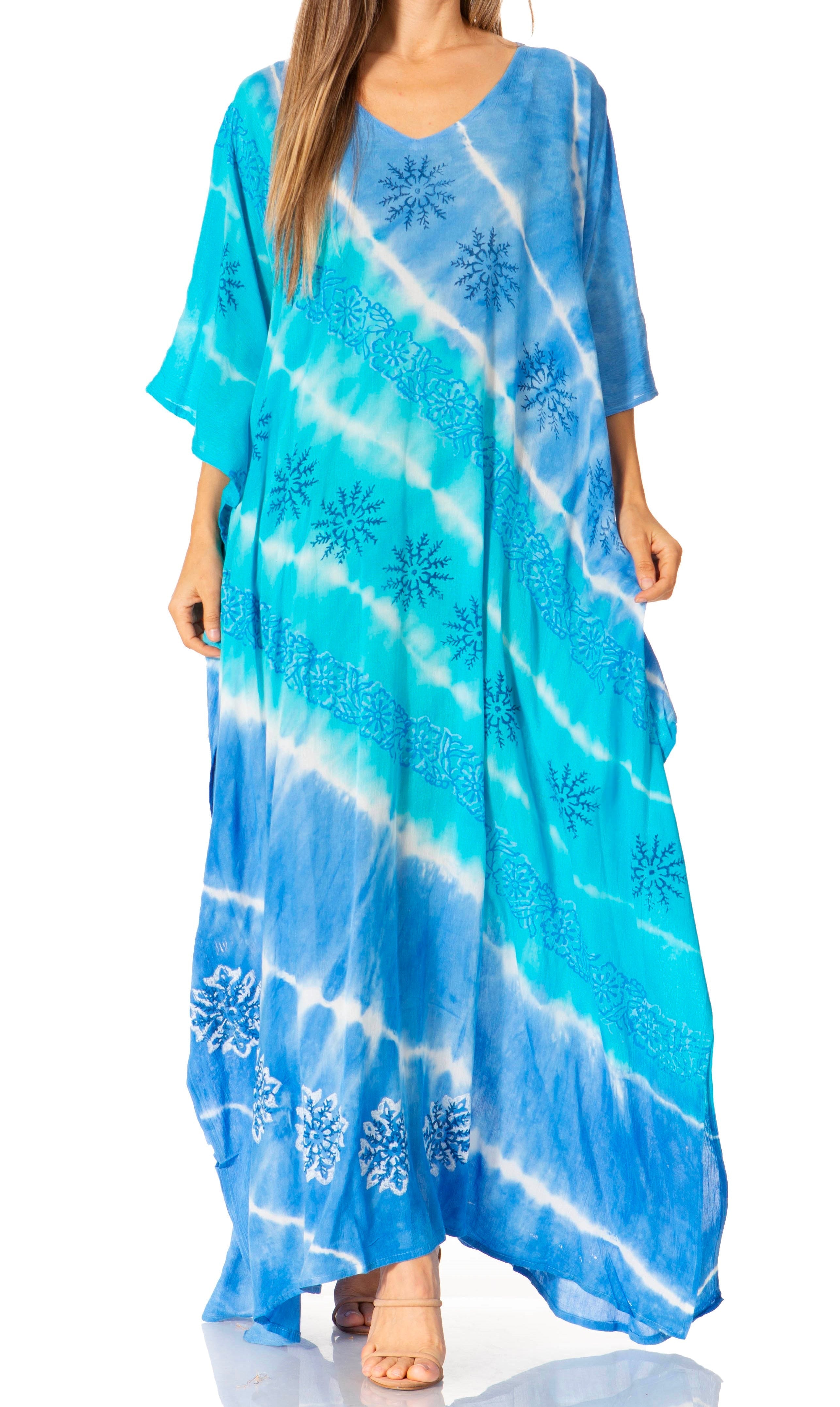 Woman wearing a blue tie-dye dress with floral patterns on a white background