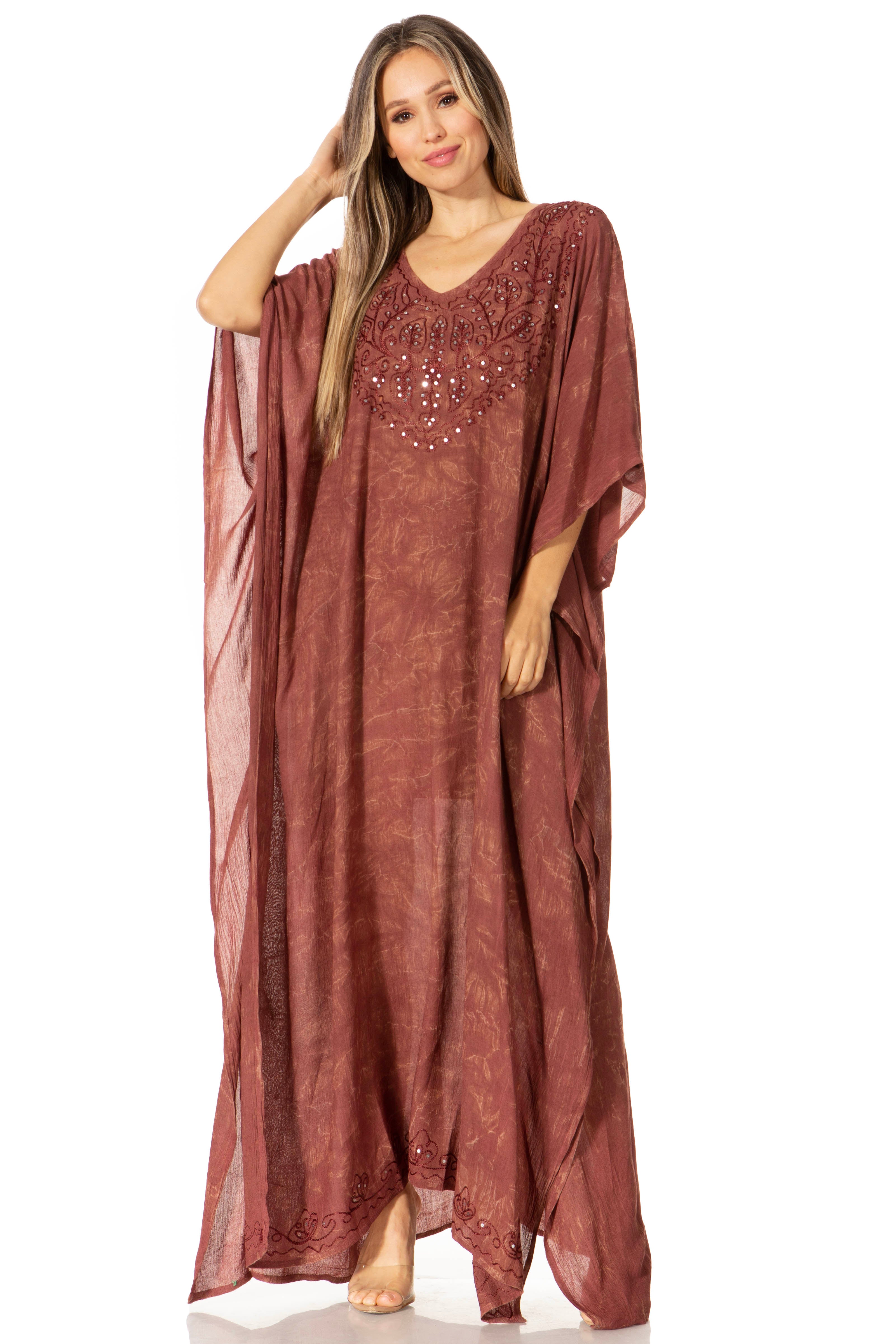 Woman wearing a long, flowing rust-colored dress with sequin embellishments on a white background