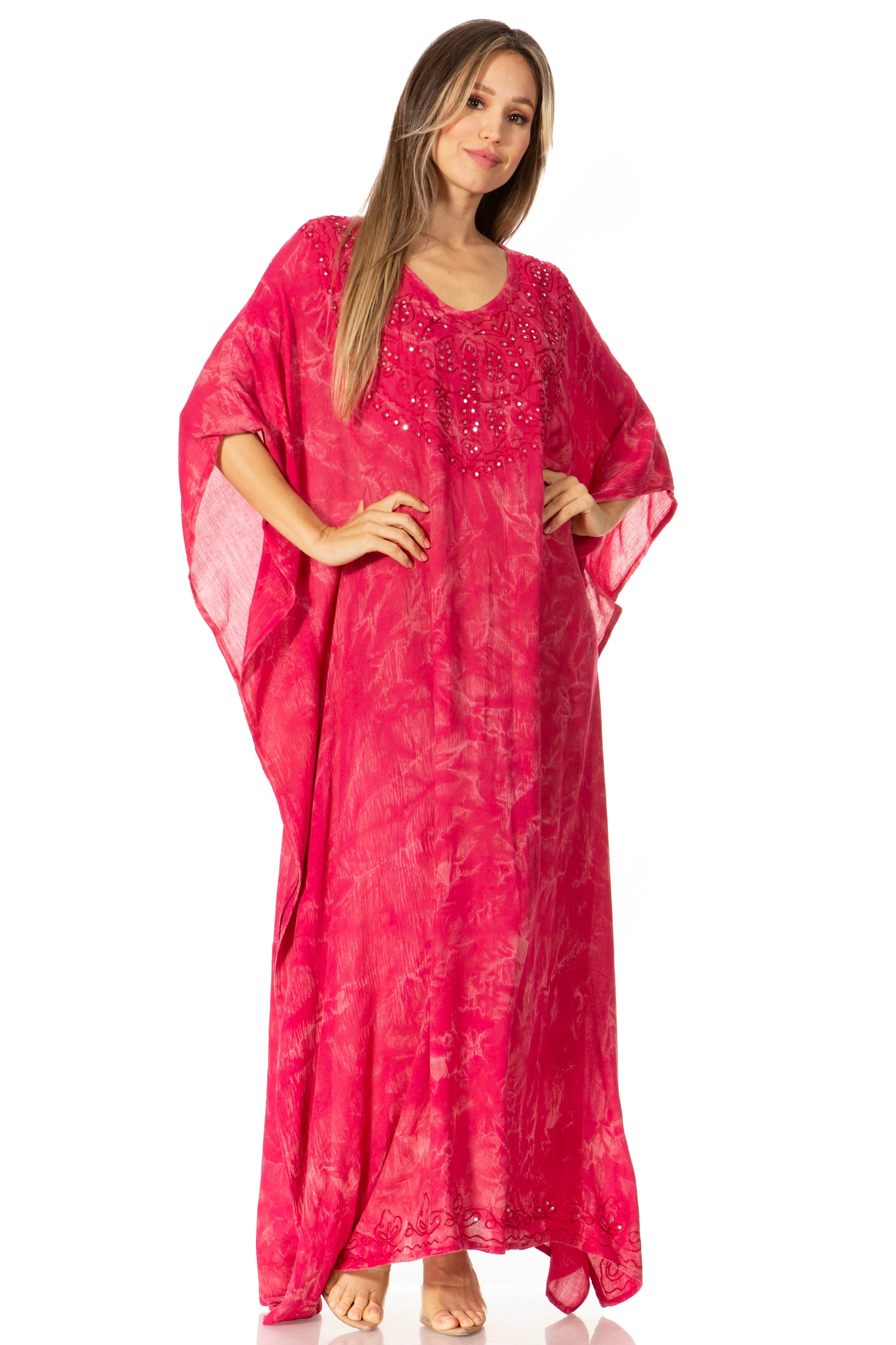 Woman wearing a pink caftan with embroidery on a white background