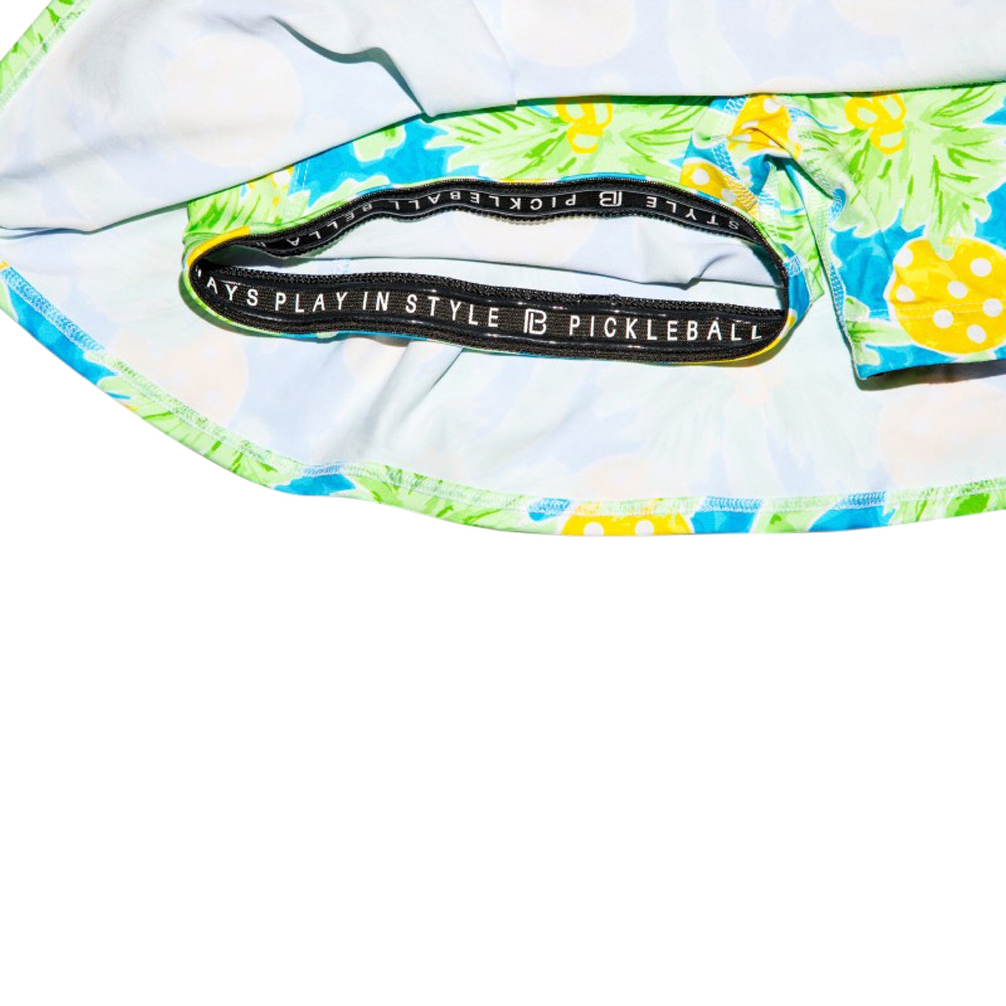 Close-up of a pickleball paddle with floral design and brand label on a white background