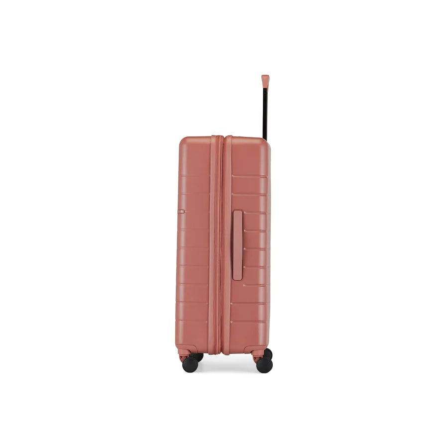 Pink suitcase with wheels on a white background