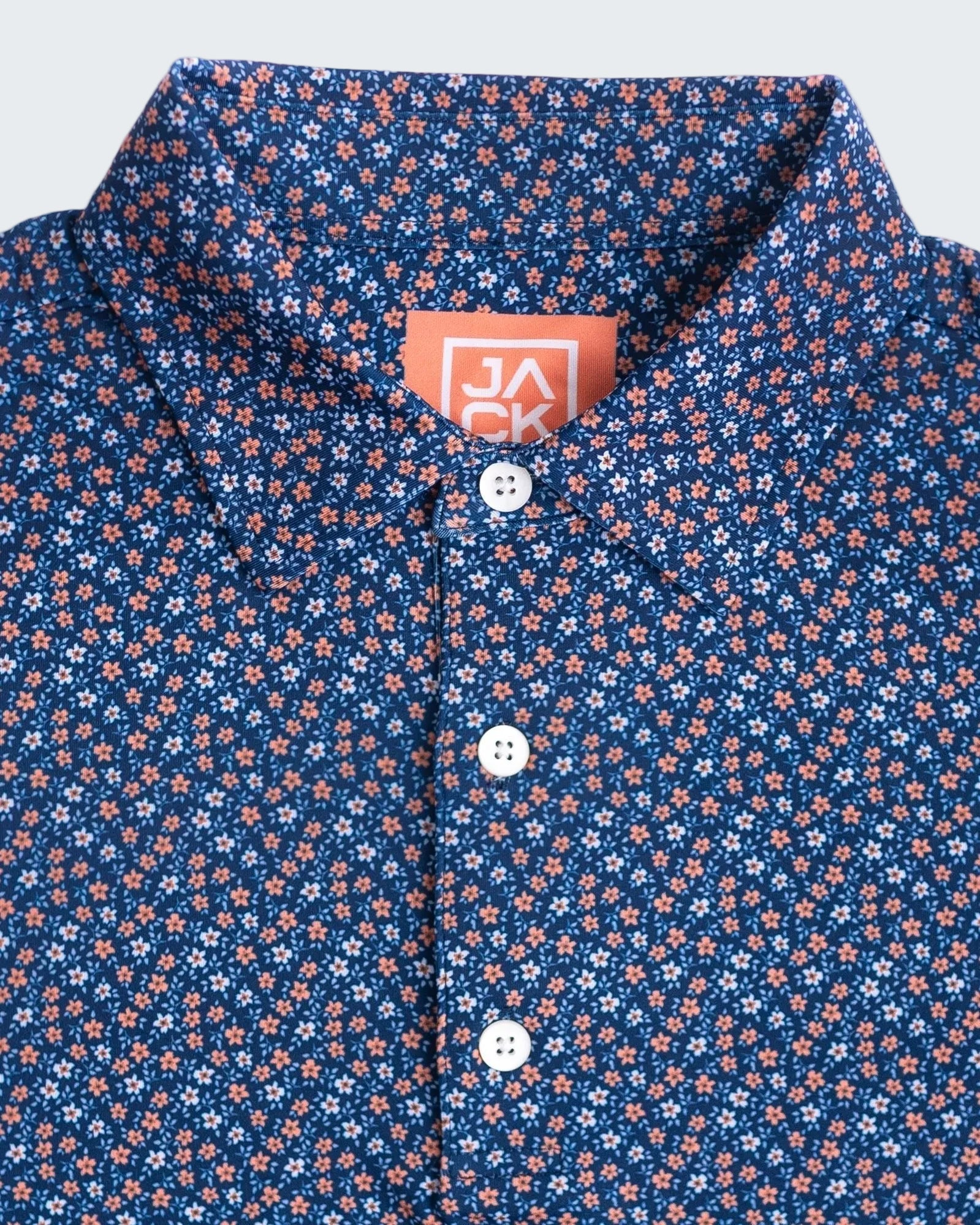 Close-up of a blue floral patterned shirt with a brand label.