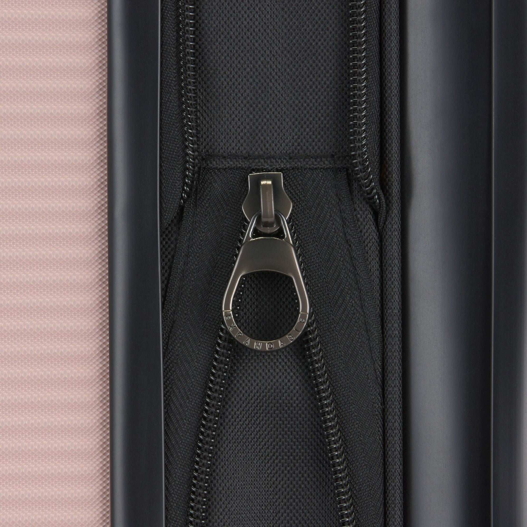 Close-up of a zipper on a suitcase with a pink and black design.