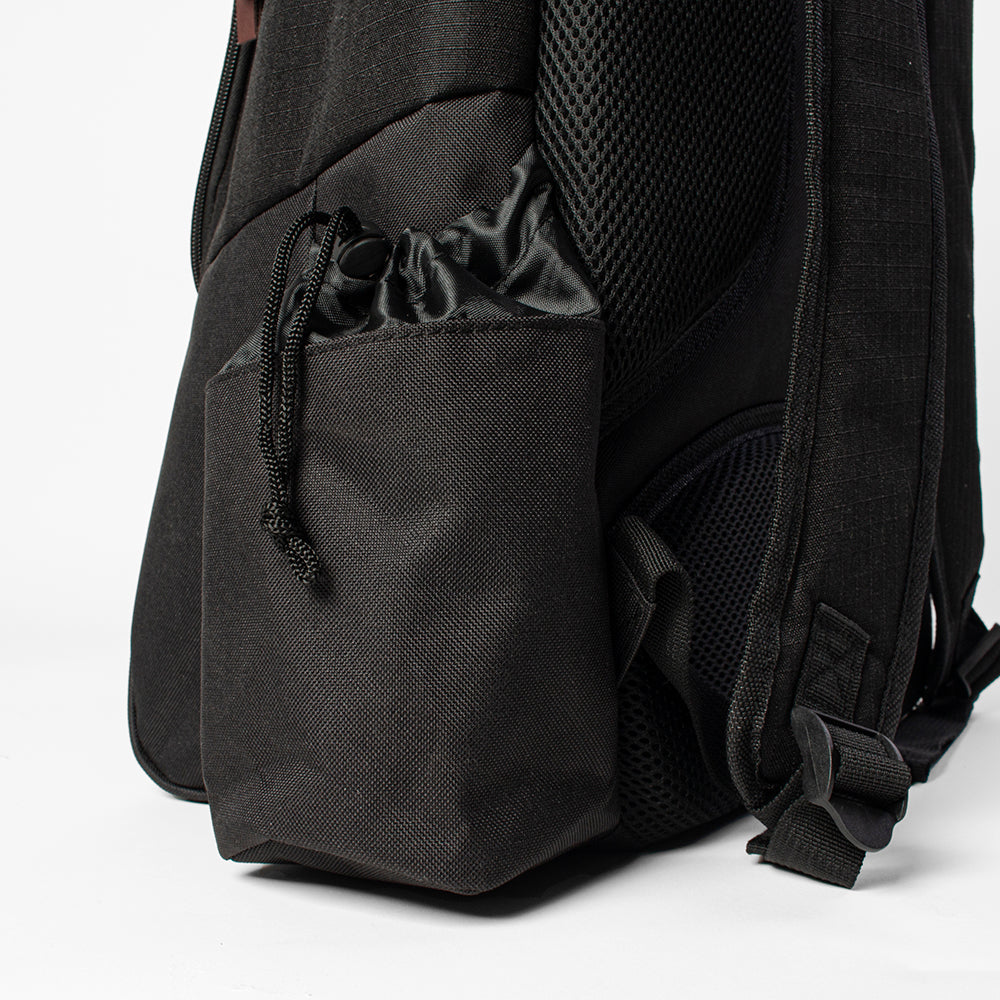 Black backpack with a drawstring pocket on a white background