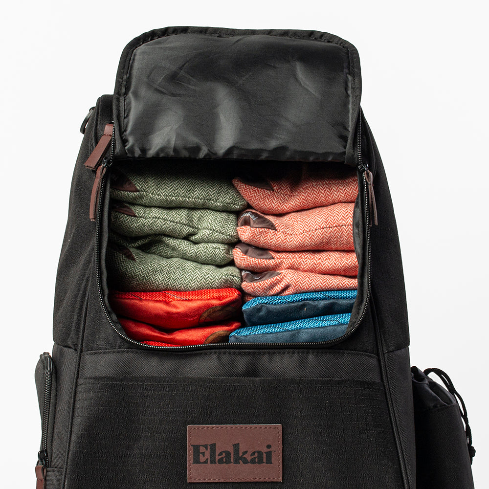Black backpack with clothes inside, featuring the Elakai brand.