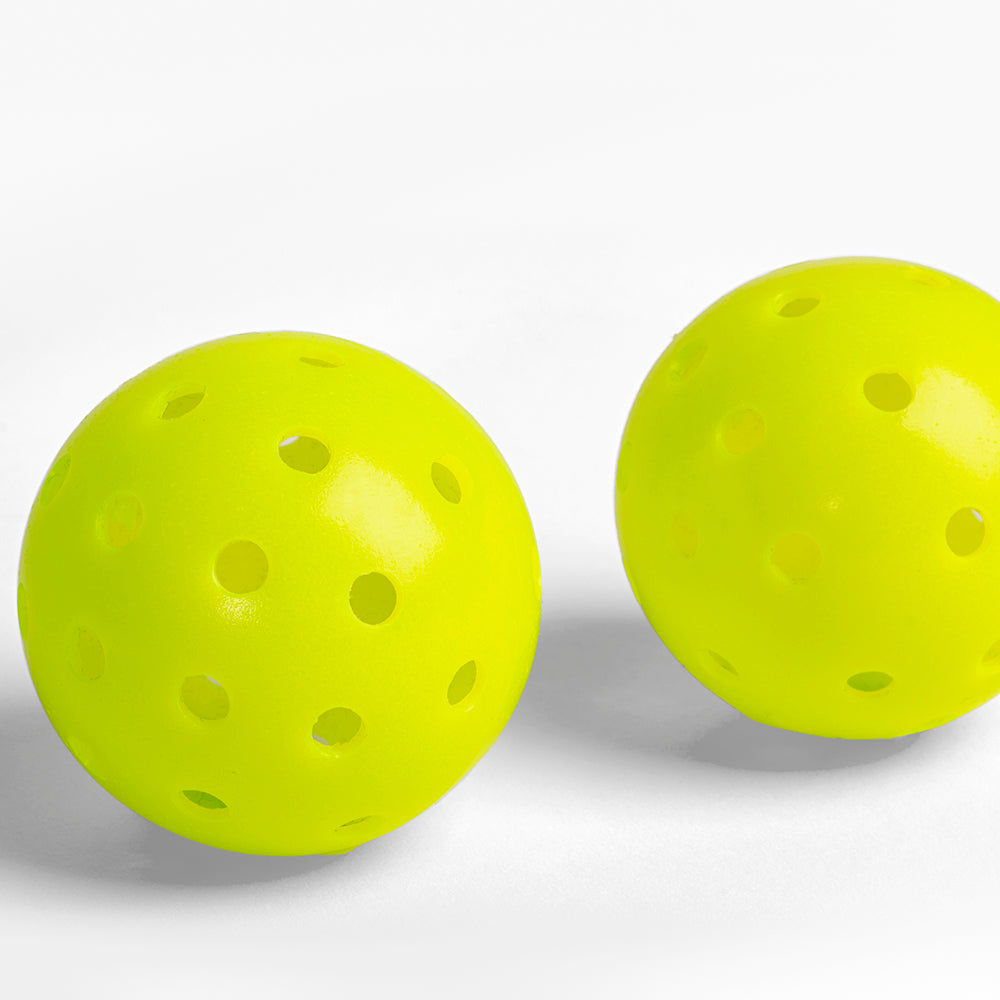 Two yellow pickleballs on a white background