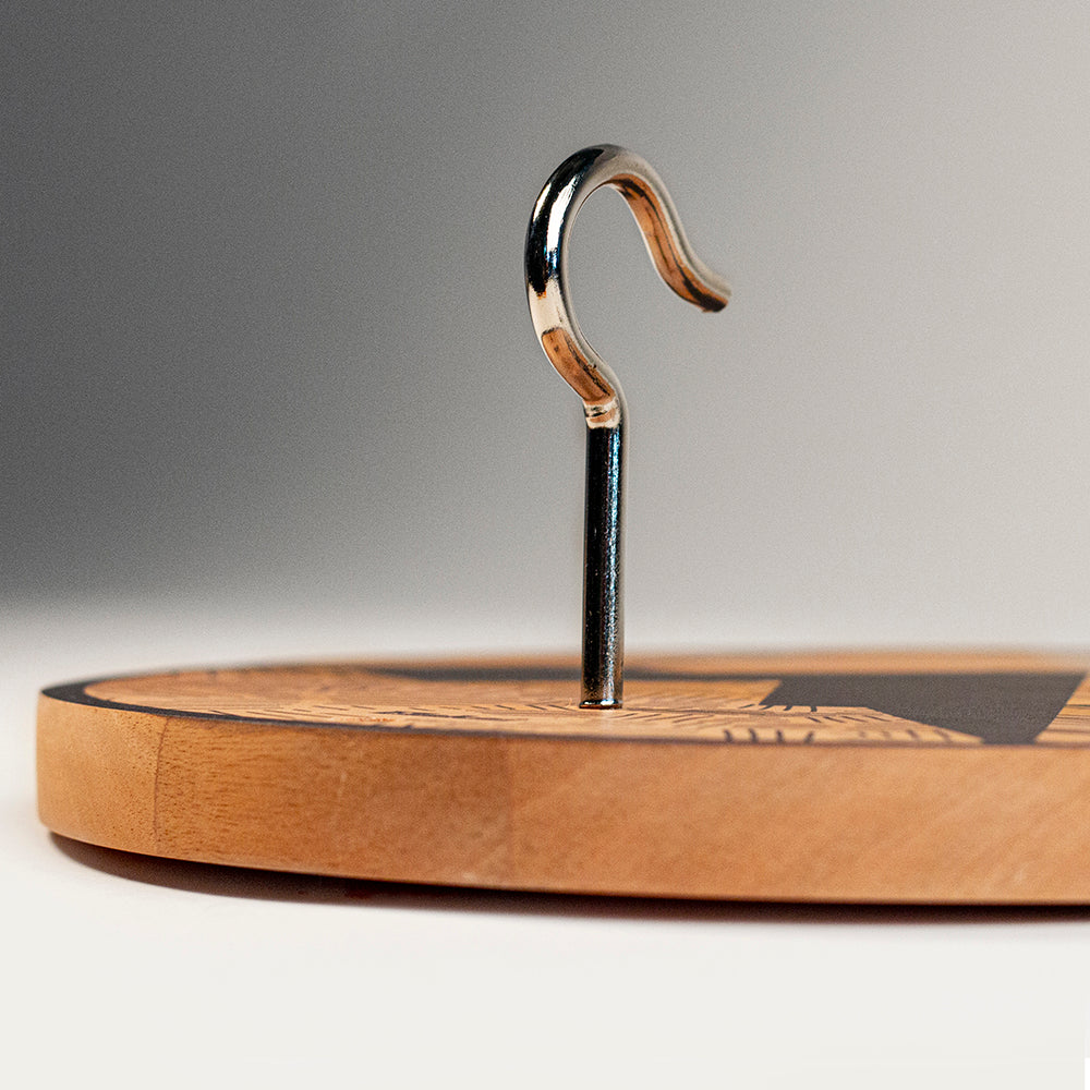 Wooden cutting board with a metal hook on a gray background