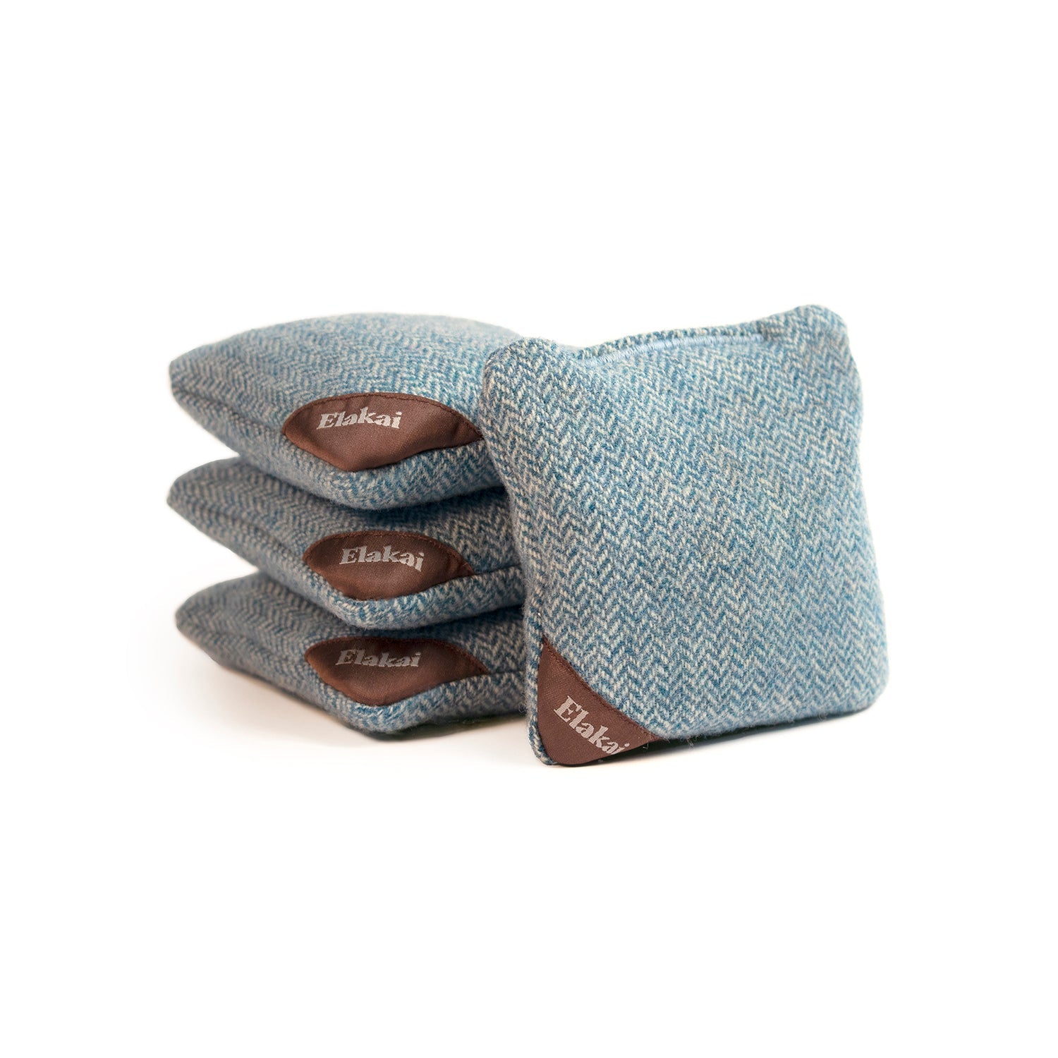 Set of four blue cornhole bags with brown leather patches on a white background