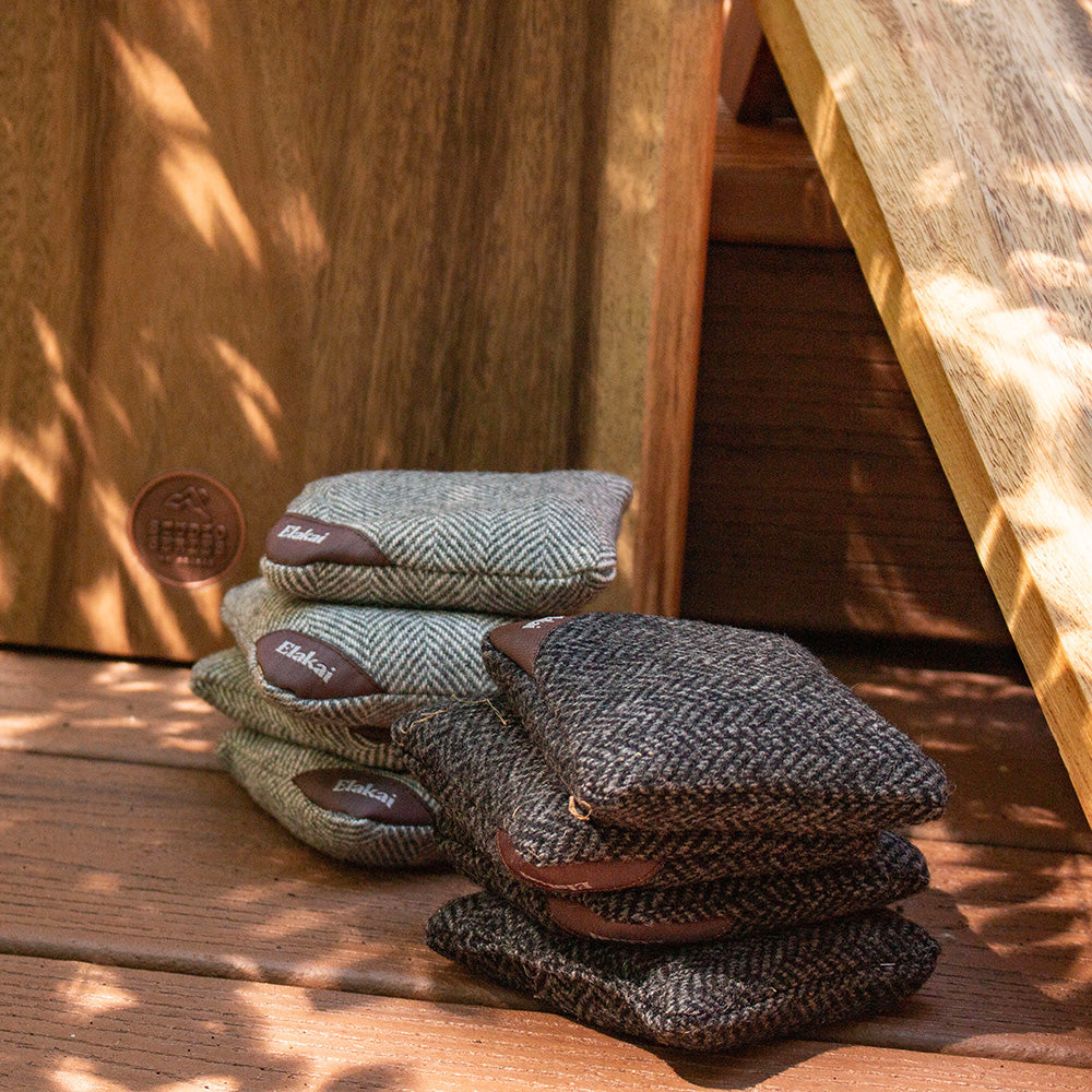 Stack of herringbone-patterned cushions on a wooden surface with a blurred background