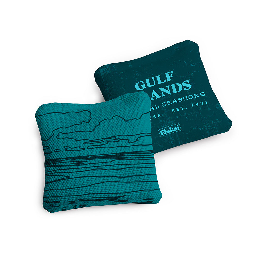Two teal pillows with a coastal design and 'Gulf Sands' text on a white background