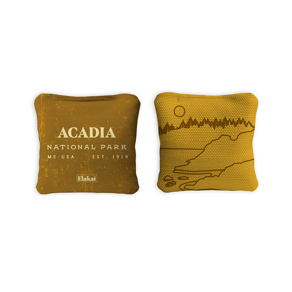 Two mustard yellow pillows with 'Acadia National Park' text and a map design on a white background.