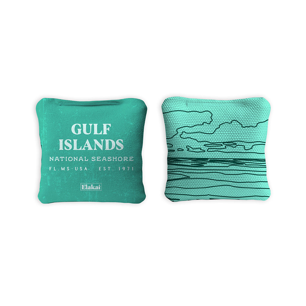 Two teal pillows with 'Gulf Islands National Seashore' text and wave design on a white background