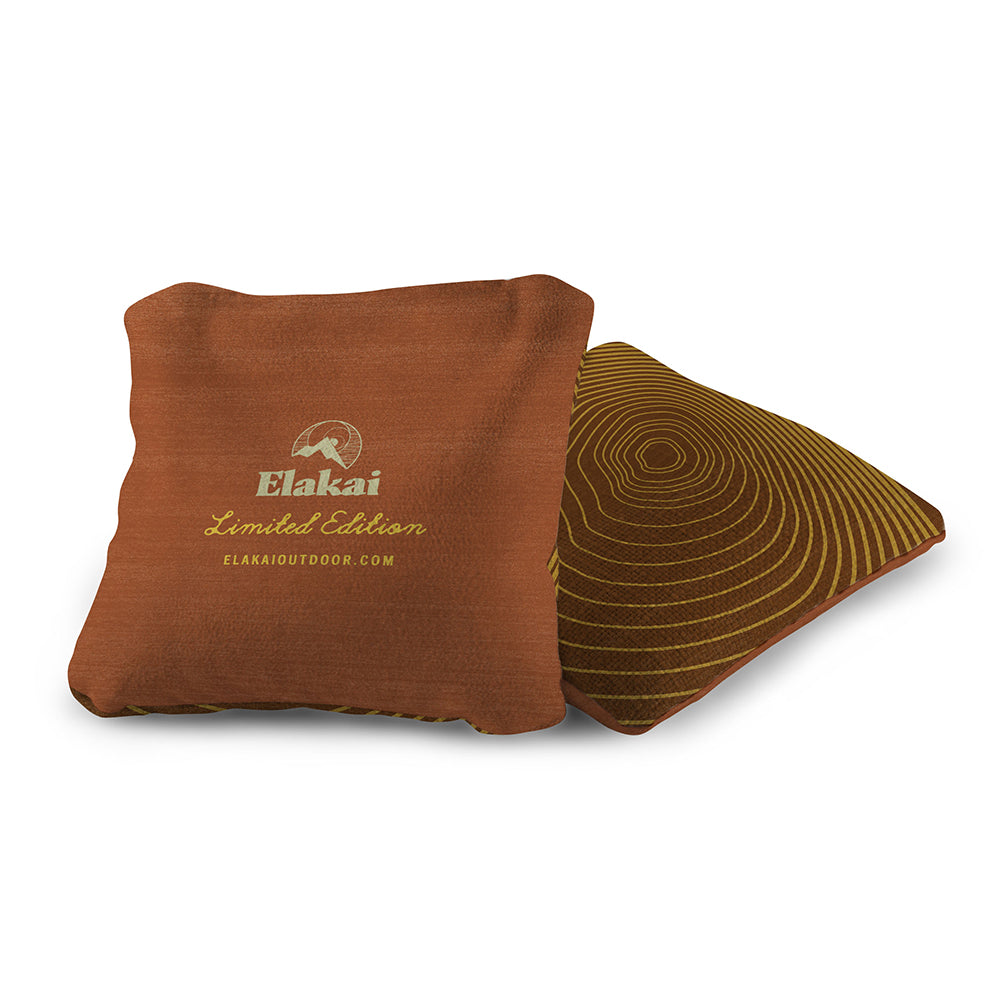 Brown pillow with Elakai logo and design on a white background