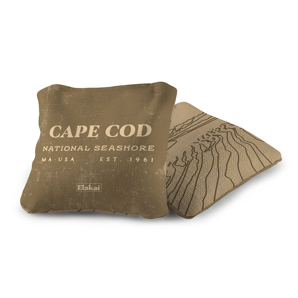 Brown pillow with 'Cape Cod National Seashore' text and a map design on a white background