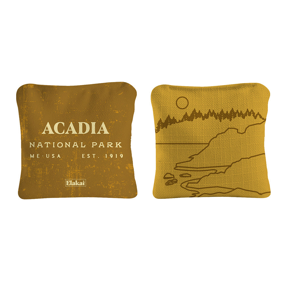 Two mustard yellow pillows with 'Acadia National Park' text and a nature illustration on a white background.