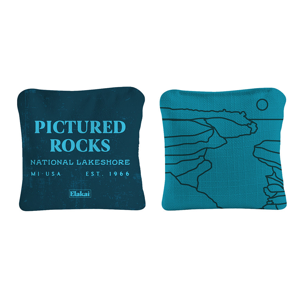 Two teal pillows with 'Pictured Rocks National Lakeshore' text and map design on a white background.