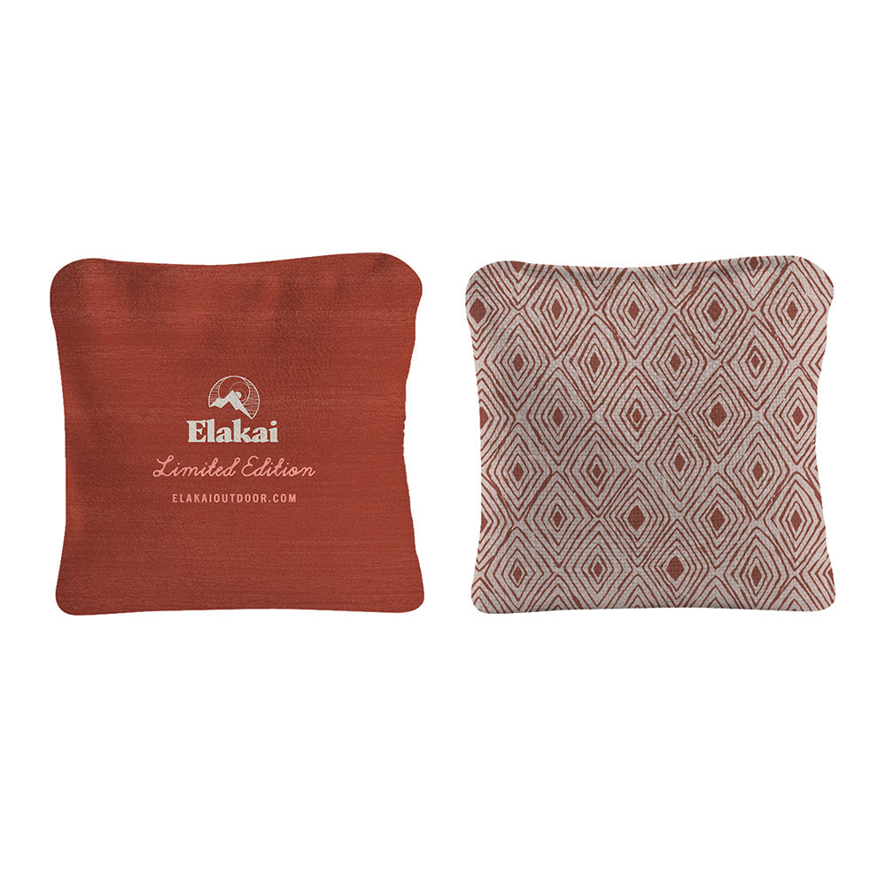 Two pillows, one red with Elakai branding and one patterned, on a white background.