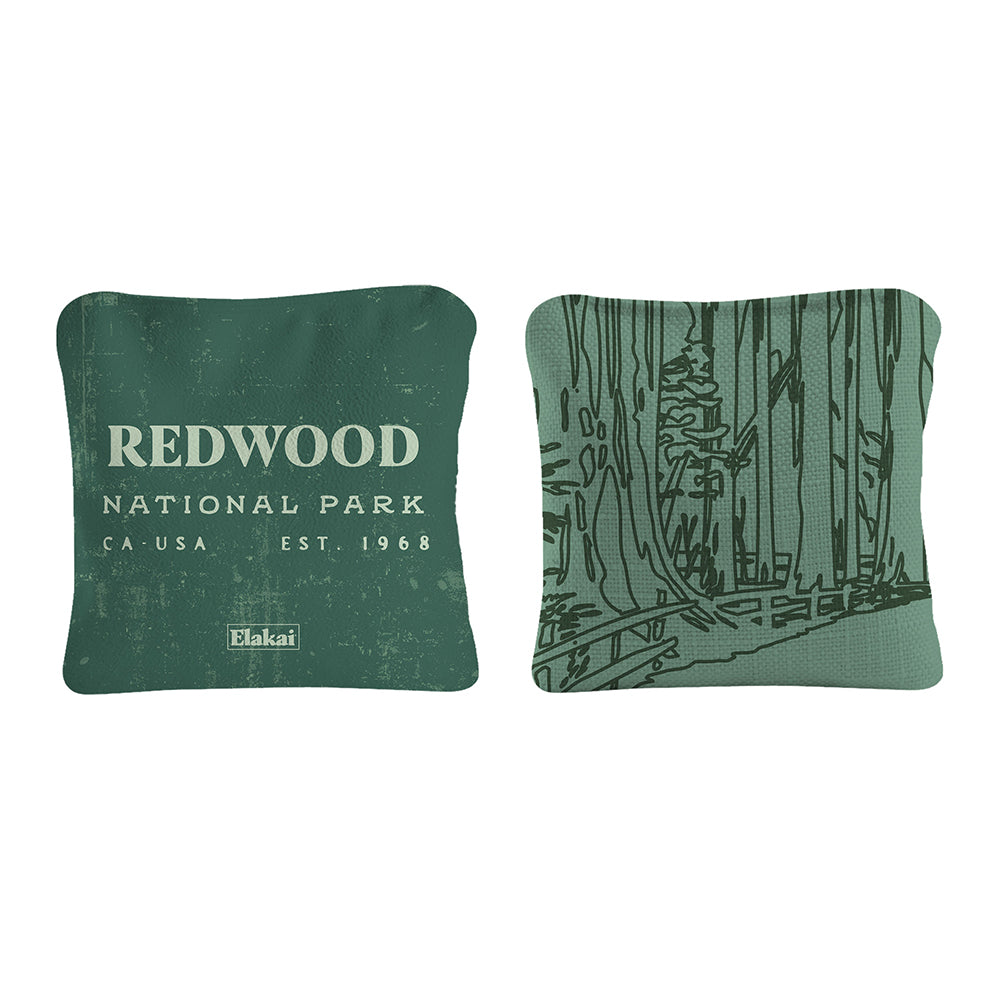 Two green pillows with 'Redwood National Park' text and forest design on a white background
