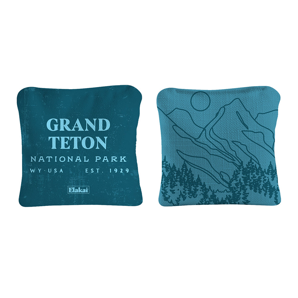Two blue pillows with 'Grand Teton National Park' text and mountain design on a white background