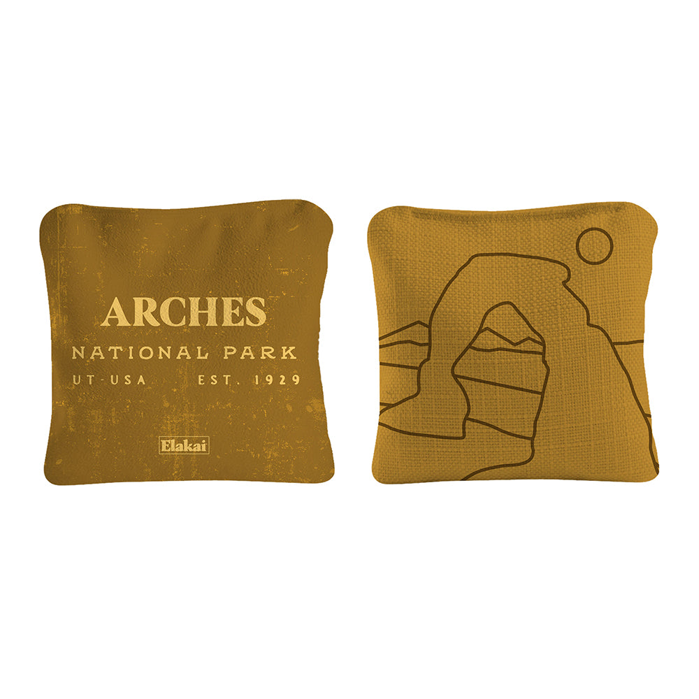 Two mustard yellow pillows with 'Arches National Park' text and logo on a white background