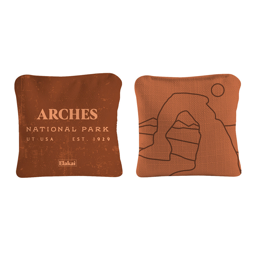 Two brown pillows with 'Arches National Park' text and logo on a white background