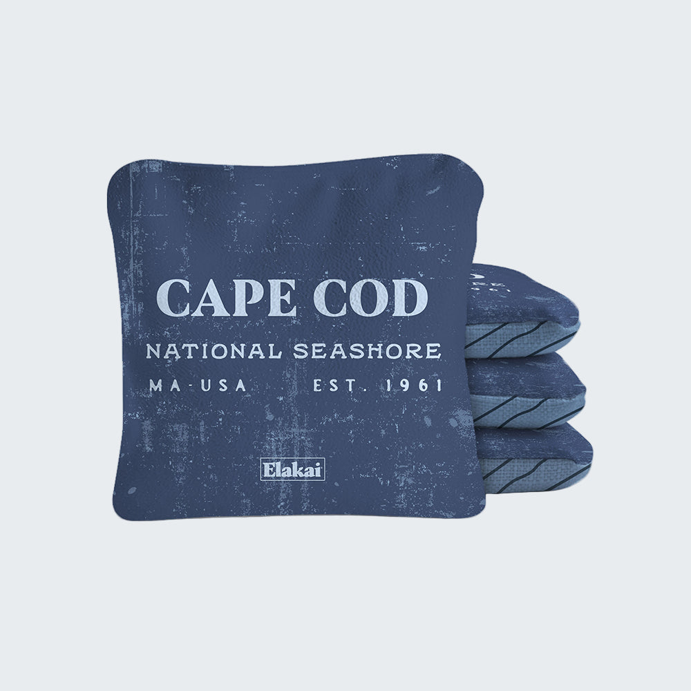 Blue pillow with 'Cape Cod National Seashore' text and Elakai branding on a white background