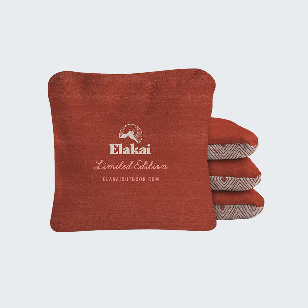 Red outdoor pillow with Elakai branding on a white background
