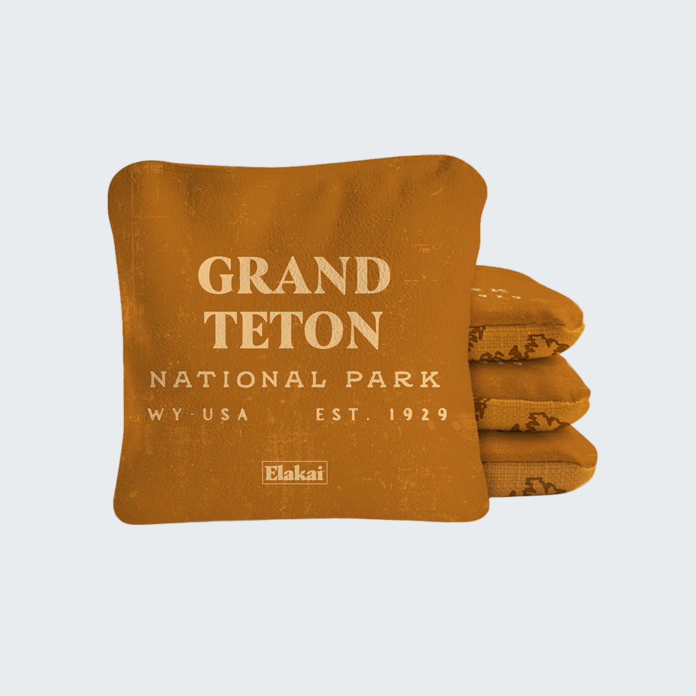 Folded orange blanket with 'Grand Teton National Park' text on a white background