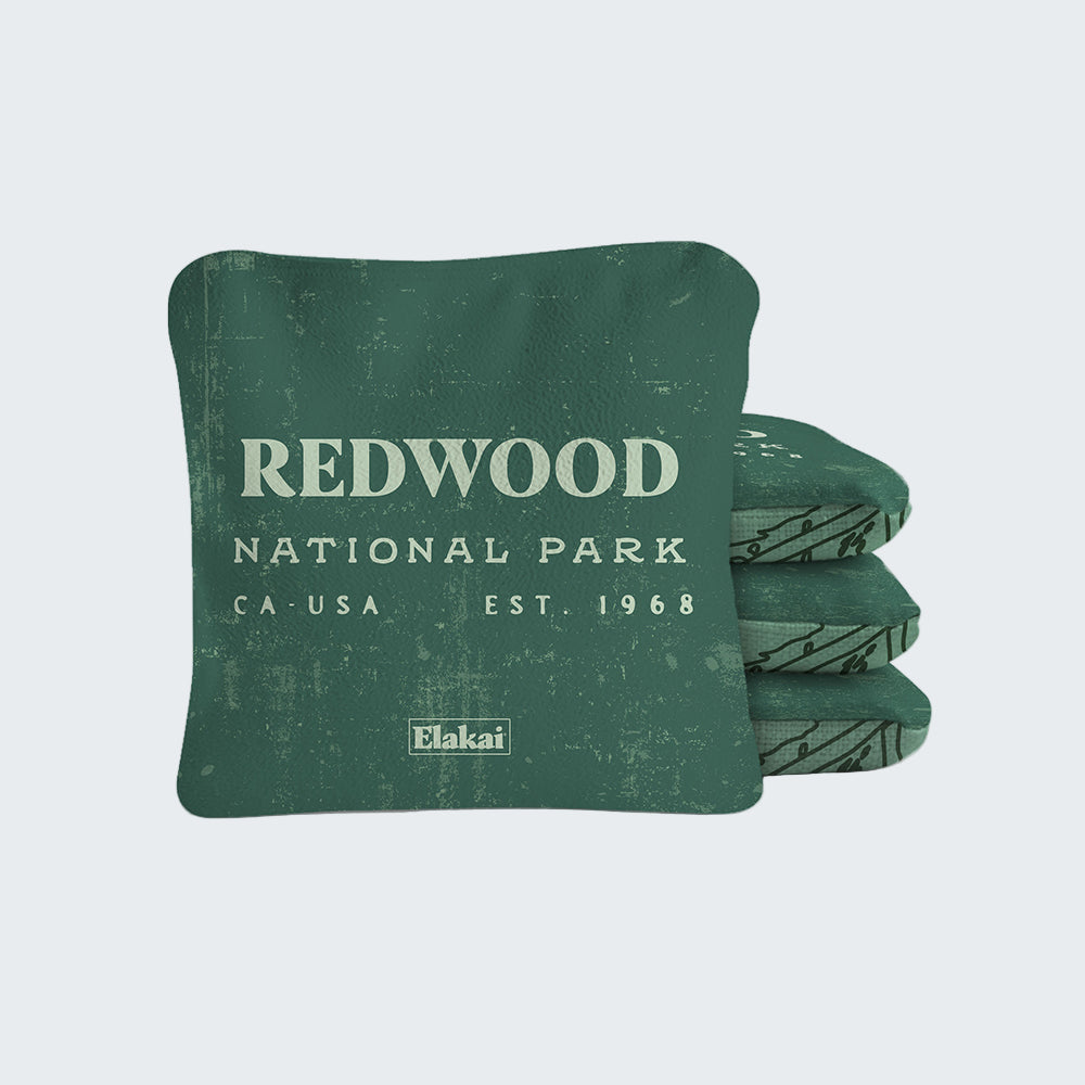 Green pillow with 'Redwood National Park' text and Elakai branding on a white background