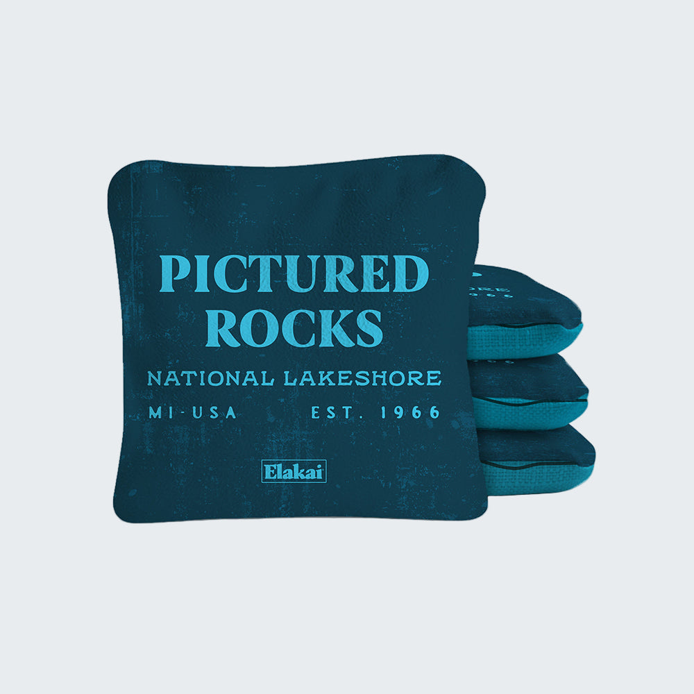 Blue pillow with 'Pictured Rocks National Lakeshore' text and Elakai branding on a white background
