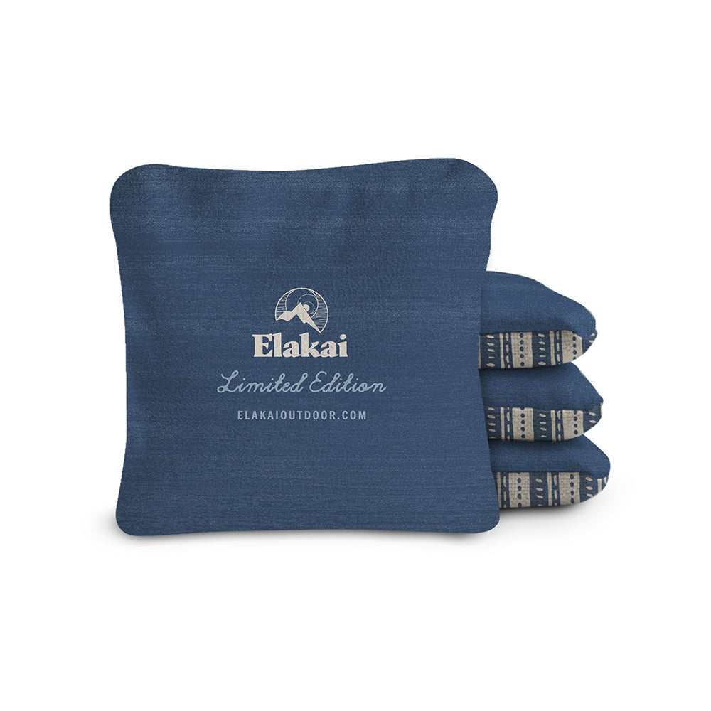 Blue cornhole bags with Elakai branding on a white background