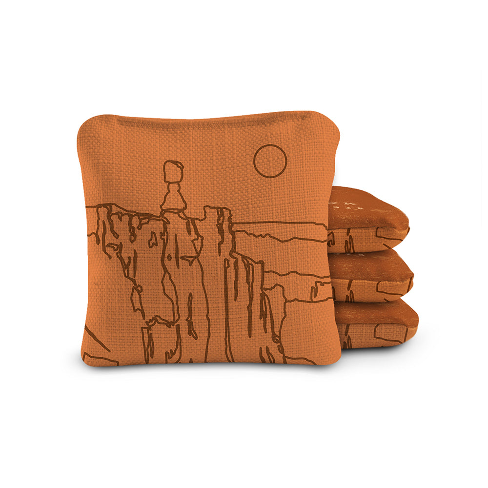 Stack of orange towels with a desert landscape design on a white background